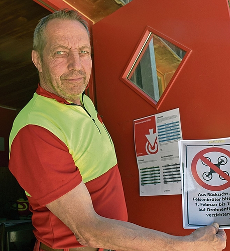 Revierförster Patrik Mosimann zeigt das Plakat mit dem Aufruf, Drohnen nicht während der Brutphase der Felsenbrüter fliegen zu lassen. 