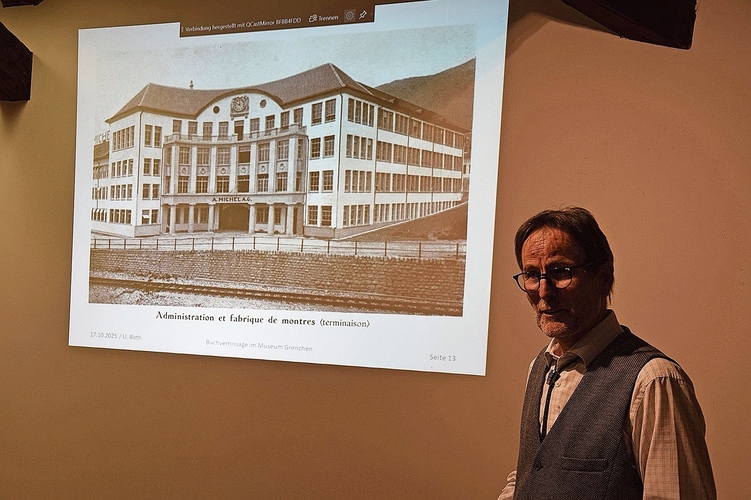 Urs Roth posiert vor dem Diabild der bekannten Fassade der Michel AG.