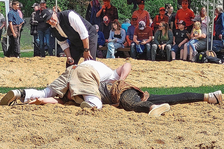 Auch im textilen Bereich ist die Schwingerdisziplin erkennbar: Der eine ist der Sennenschwinger in dunkler Hose und farbigem Edelweiss-Hemd und der andere, der Turnschwinger, präsentiert sich in weisser Hose und weissem Shirt. 
