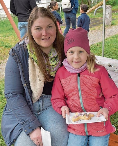 Lennja (7) hat ein Guetzli schön farbig dekoriert. Links Eveline Streit.