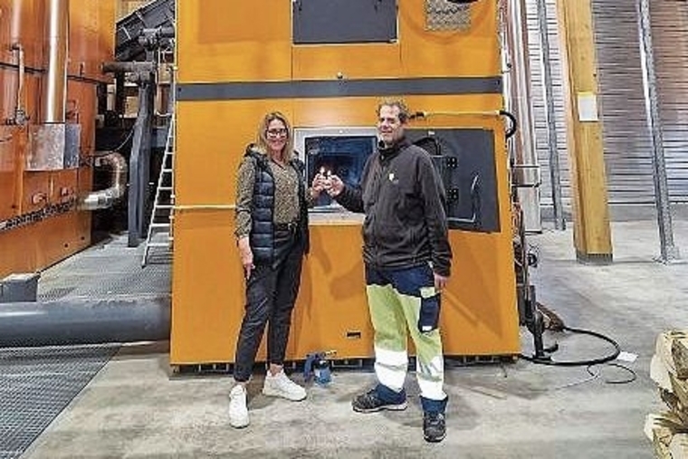 Heizkessel Lengnau: Geschäftsführerin Monika Gribi und Thomas Scheurer, Leitung Umbau, feuern den neuen Holzheizkessel ein.Bild: WärmeLengnau