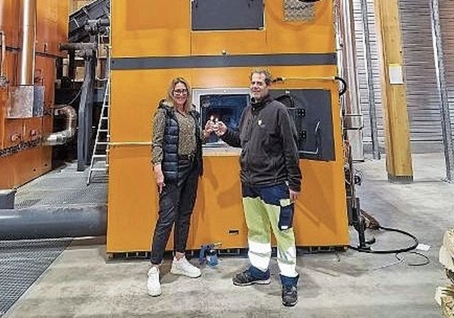 Heizkessel Lengnau: Geschäftsführerin Monika Gribi und Thomas Scheurer, Leitung Umbau, feuern den neuen Holzheizkessel ein.Bild: WärmeLengnau