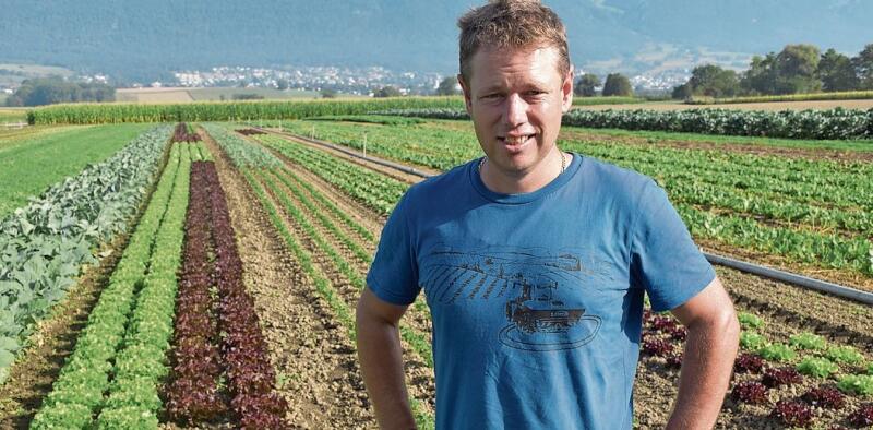 Welch ein Anblick: Der Staader Landwirt Daniel Stauffer vor einem langen Beet mit Sommersalaten und anderen Köstlichkeiten, die aus der Erde wachsen.