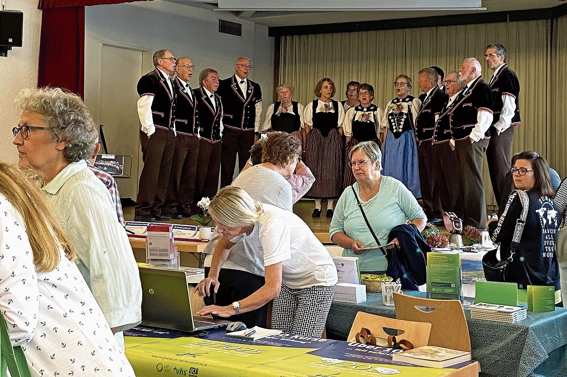 Emsiges Treiben vor der Eröffnung bei den Ständen, während auf der Bühne der Jodlerklub Bärgbrünnli schon mal am Einsingen ist.